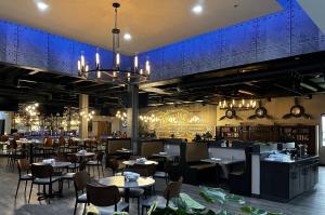 a restaurant with tables and chairs and a bar at Wyndham Indianapolis Airport in Indianapolis