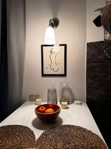 a bowl of fruit on a table with a lamp at A casa di Tina in Genzano di Roma
