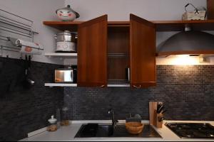 a kitchen with wooden cabinets and a sink and a stove at A casa di Tina in Genzano di Roma