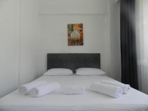 a white bed with white sheets and towels on it at Gökçeada Chrysi Petra pansiyon in Gokceada Town