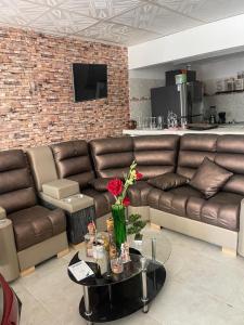 a living room with a brown leather couch and a table at La plata huila in La Plata