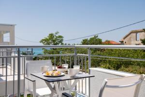 a table with a plate of food on a balcony at Sourinis Luxury Suites in Limenaria