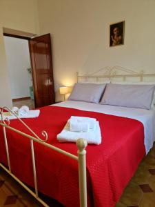 a bed with a red blanket and two towels on it at Relax in campagna - Aquino in Aquino