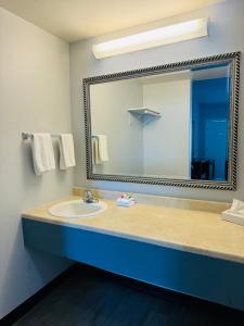 uma casa de banho com um lavatório e um espelho grande em Baymont by Wyndham Ridgecrest em Ridgecrest