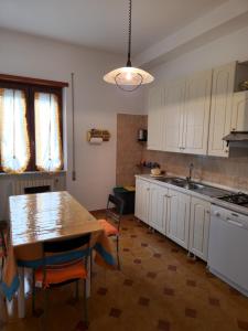 a kitchen with white cabinets and a table and a sink at Relax in campagna - Aquino in Aquino