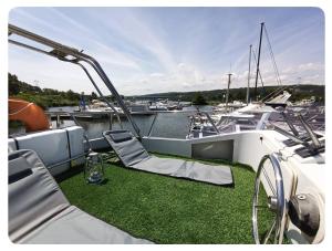 a boat with two chairs on the dock with boats in the water at Nuit insolite et cocon in Valence