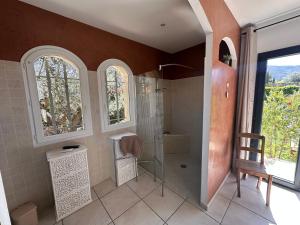 索雷德La villa des oliviers的带淋浴的浴室、椅子和窗户