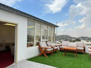 a patio with chairs and a table on a balcony at فيلا فيو السودة Villa View Al Soudah in Sawdāʼ +24 photos