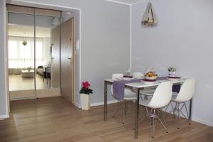 a dining room with a table and white chairs at SMM Apartament Stettin in Szczecin