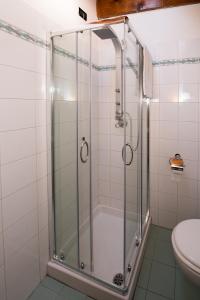 una doccia con una porta in vetro in un bagno di Residenza Contrada Tedesca a Trento Altre 27 foto