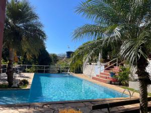 a swimming pool in a yard with palm trees at Casa de Campo Terra da Paz in Itatiba