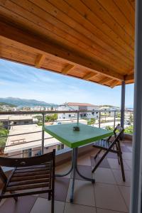 a green table and two chairs on a balcony at Villa Hamza Ksamil in Ksamil