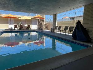 a large swimming pool with blue water in a building at Grand Inn in Fullerton