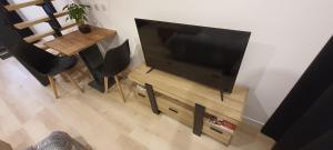 a flat screen tv sitting on a stand next to a table at Gîte des Côtes de Vezon in Marieulles