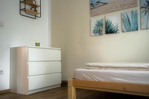 a bedroom with a bed and a dresser and pictures at Anca's Haus in Schwanstetten