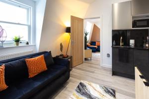 a living room with a black couch and a kitchen at The Lanes Diamond - Rose Platinum Properties in Brighton & Hove