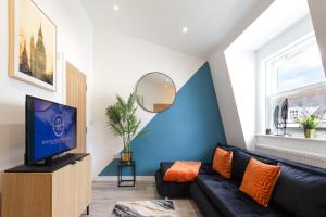 a living room with a black couch and a tv at The Lanes Diamond - Rose Platinum Properties in Brighton & Hove