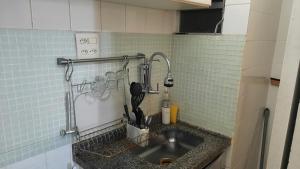 a kitchen sink with utensils on a tiled wall at Copacabana POSTO 4 Temporada in Copacabana +14 photos