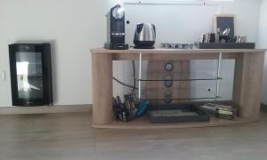 a small wooden table with a microwave and a television at Maison Chauvin in Château-du-Loir