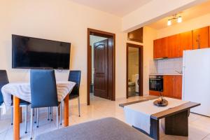 cocina y sala de estar con mesa y TV en Papi's Free Parking Apartments 2 - 1 Bedroom, en Alexandroupoli