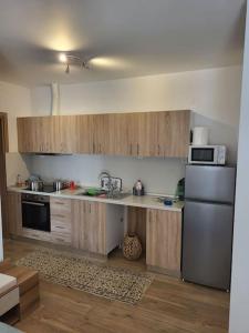 a kitchen with wooden cabinets and a stainless steel refrigerator at Ολοκαίνουρια Iosif's residence in Perea