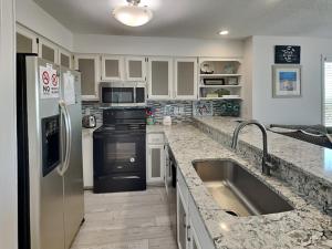a kitchen with a stainless steel refrigerator and a sink at Haileys Hideaway in Surf City