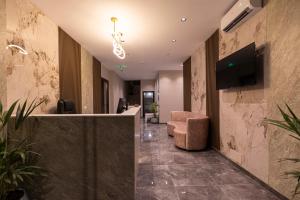 a lobby with a waiting area with a chair and a tv at Diol Hotel Ksamil in Ksamil