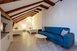a living room with a blue couch and a table at Bed & Breakfast Blanc in Pučišća