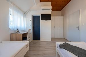 a bedroom with two beds and a desk at Bed & Breakfast Blanc in Pučišća