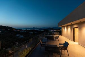 a balcony with chairs and tables at night at Diol Hotel Ksamil in Ksamil