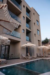 a hotel with a swimming pool and chairs and umbrellas at Diol Hotel Ksamil in Ksamil