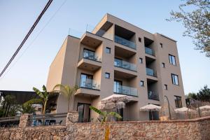 a building with a stone wall in front of it at Diol Hotel Ksamil in Ksamil