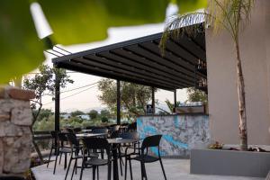 a restaurant with tables and chairs under awning at Diol Hotel Ksamil in Ksamil