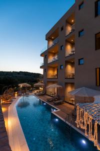 a hotel with a swimming pool in front of a building at Diol Hotel Ksamil in Ksamil