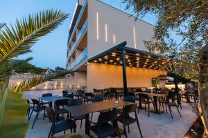 a restaurant with tables and chairs in front of a building at Diol Hotel Ksamil in Ksamil