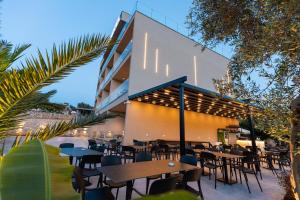 a restaurant with tables and chairs in front of a building at Diol Hotel Ksamil in Ksamil