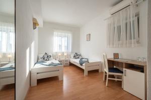 a small room with two beds and a desk at Bed & Breakfast Blanc in Pučišća