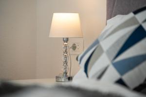 a lamp sitting on a table next to a bed at Bed & Breakfast Blanc in Pučišća