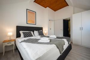 a bedroom with a large bed and a night stand at Bed & Breakfast Blanc in Pučišća