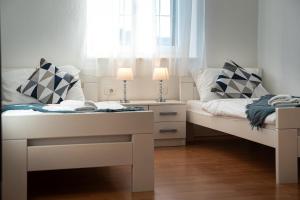two white beds in a room with a window at Bed & Breakfast Blanc in Pučišća