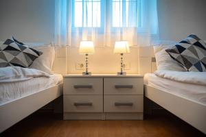 a bedroom with two beds and two lamps on a night stand at Bed & Breakfast Blanc in Pučišća