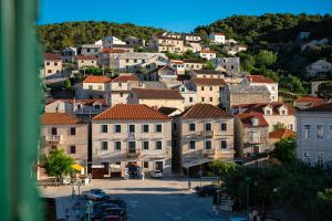 a town on a hill with houses and cars at Bed & Breakfast Blanc in Pučišća