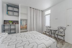 a bedroom with a bed and a table and chairs at Primavera Tranquil Retreat 2-Bedroom Apartment with Balcony, Garden View & Fiber WiFi in Arona +12 photos