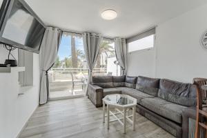 a living room with a couch and a table at Primavera Tranquil Retreat 2-Bedroom Apartment with Balcony, Garden View & Fiber WiFi in Arona