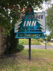 a sign that says we service inn a room you will love to remember at Ludington Blue Spruce Inn in Ludington
