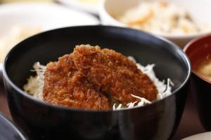a black bowl filled with rice and meat at Dormy Inn Takasaki in Takasaki