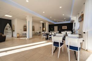 a dining room with white tables and white chairs at Bed & Breakfast Blanc in Pučišća