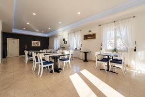 a dining room with tables and chairs and windows at Bed & Breakfast Blanc in Pučišća