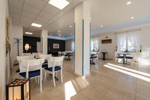 a dining room with white chairs and tables at Bed & Breakfast Blanc in Pučišća
