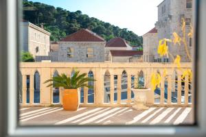 a balcony with two potted plants and a bridge at Bed & Breakfast Blanc in Pučišća